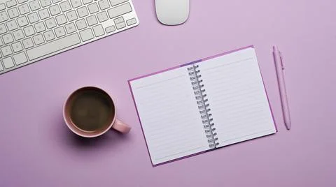 Flat lay empty notebook, coffee cup and pen on purple background. Stock Photos