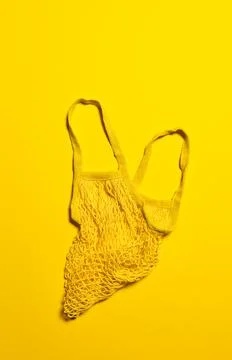 Flat lay with empty yellow mesh bag on yellow Stock Photos