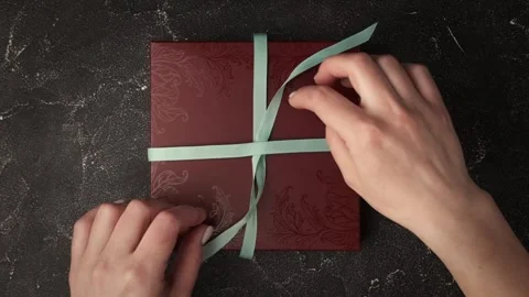 Flat lay of female hands unpack a present in a burgundy box Stock Footage 240324022