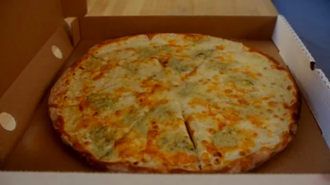 Flat lay - female opening box with 4 cheese pizza. Video stock 244709300