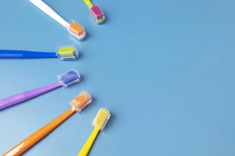 Flat Lay Few of Multicolored Toothbrushes Lying in Shape Of Sun On Blue Stock Photos