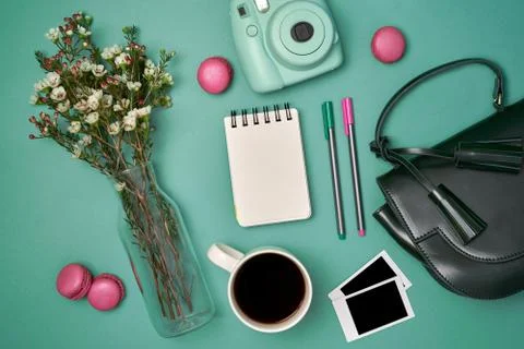 Flat lay with flowers, analog camera, pictures, cup of coffee, note, pens, bag Stock Photos
