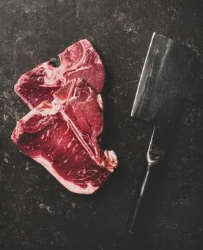 Flat-lay of fresh beef meat t-bone steaks and butchers cleaver Stock Photos