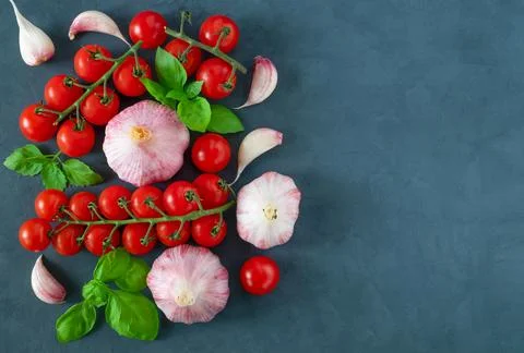 Flat lay of fresh cherry tomatoes, garlic and basil leaves. Stock Photos