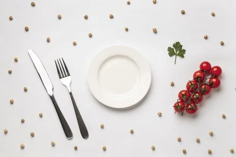 Flat lay fresh tomatoes with plate cutlery Stock Photos