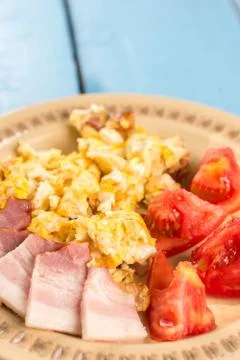 Flat lay fried eggs breakfast with domestic raw bacon and tomato salad Stock Photos