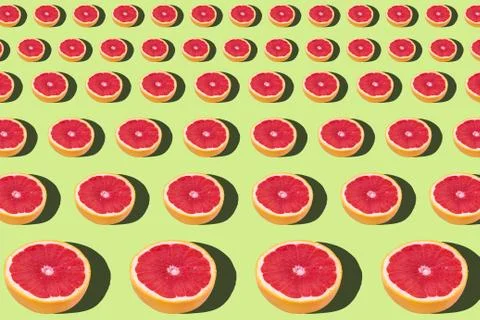 Flat lay fruit pattern of fresh grapefruit slices on green background. Stock Photos
