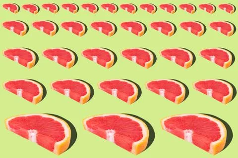 Flat lay fruit pattern of fresh grapefruit slices on green background. Stock Photos