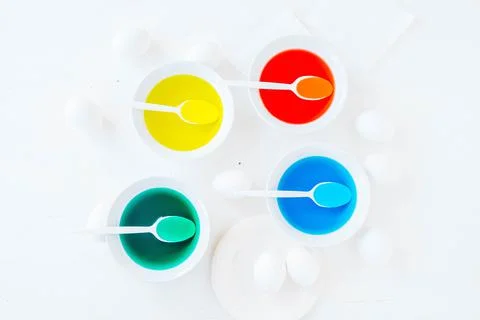 Flat lay getting ready for Easter, white eggs and liquid food coloring Stock Photos