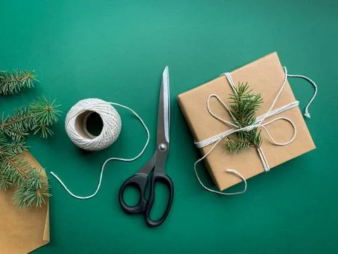 Flat lay with gift box, clews of rope, paper and scissors on green backgrond Stock Photos