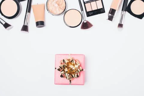 Flat lay gift box next to women's makeup Stock Photos