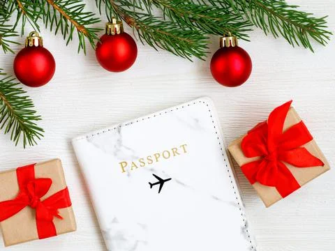 Flat lay with gift boxes, Christmas tree branches, red balls, foreign passpor Stock Photos