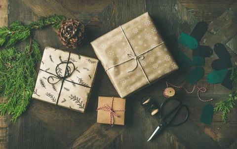 Flat-lay of gift boxes, rope, fur branches, scissors, cones, stickers Stock Photos