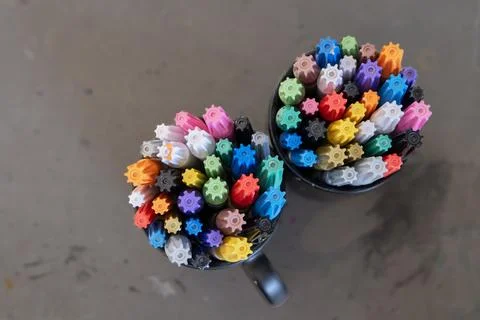 Flat lay of a glasses filled with various colorful marker pens resting on a.. Фото