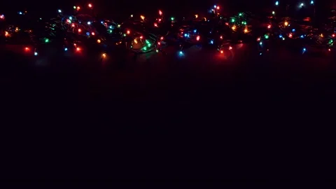 Flat lay glowing Christmas lights with copy space on dark plank background. Stock Footage 143909770