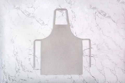 Flat lay of gray apron on marble background Stock Photos
