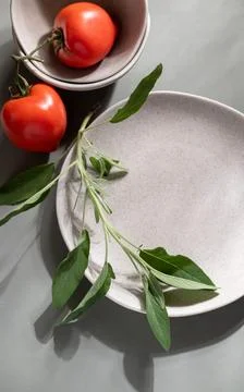 Flat lay of gray monochrome plates with sage. Stock Photos