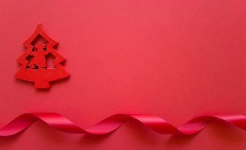 Flat lay greeting card with red Christmas tree and red ribbon on red backgrou Stock Photos