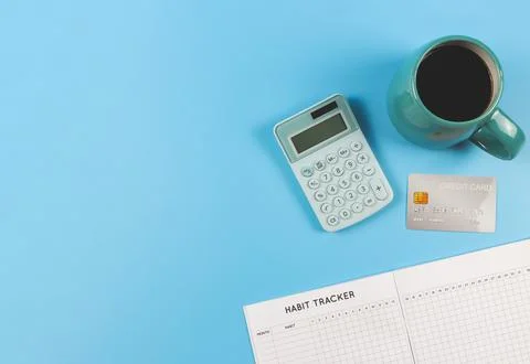 Flat lay of habit tracker book,  blue cup of black coffee, blue calculator an Stock Photos