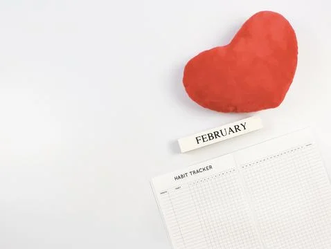 Flat lay of habit tracker book, wooden calendar February,  red heart shape .. Stock Photos