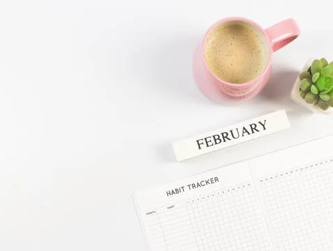 Flat lay of habit tracker book, wooden calendar February,  pink  cup of bla.. Stock Photos