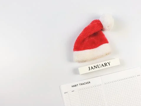 Flat lay of habit tracker book, wooden calendar January, red Christmas Sant.. Stock Photos