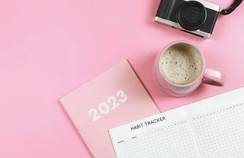 Flat lay of habit tracker book on pink diary or planner 2023, pink cup of c.. Stock Photos