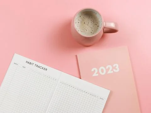 Flat lay of habit tracker book on pink diary or planner 2023 and pink cup o.. Stock Photos