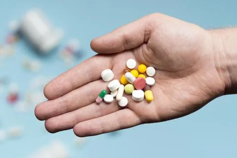 Flat lay hand holding assortment pills Stock Photos