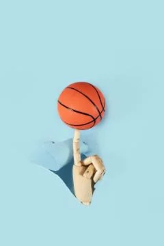 Flat lay of hand holding small basketball ball minimal creative concept. Stock Photos