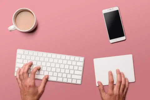 Flat lay with hands, white key board, track pad, smartphone and coffee on pin Stock Photos