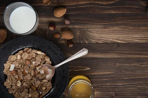 Flat lay of healthy breakfast with nuts and corn flakes on brown rustic backg Foto stock
