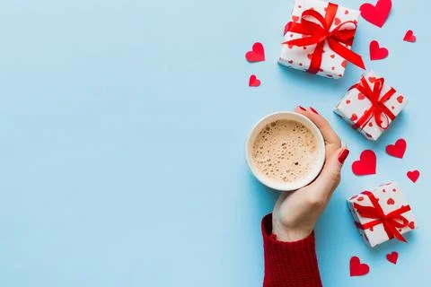 Flat lay of heart shaped cup of black coffee in the hands of women on colored Stock Photos