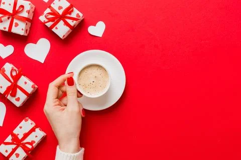Flat lay of heart shaped cup of black coffee in the hands of women on colored Stock Photos