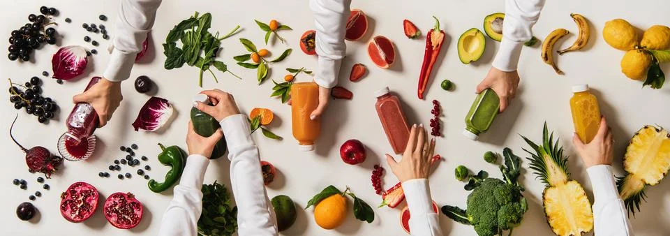 Flat-lay of human hands keeping bottles with fresh juices Stock-Fotos