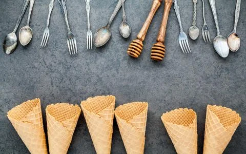 Flat lay ice cream cones collection , spoons ,fork and honey dipper on dark s Stock-Fotos