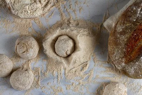 Flat lay image of bread loaves, dough ingredients, a bowl of flour, a sourdou Stock Photos