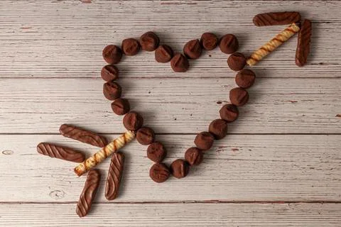 Flat lay image of Chocolate truffles designed in heart shape with arrow Stock Photos