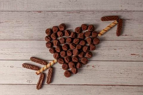 Flat lay image of Chocolate truffles designed in heart shape with an arrow Stock Photos