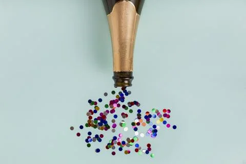 Flat lay image featuring a bottle of champagne, champagne glass, and vibrant  Fotos de archivo