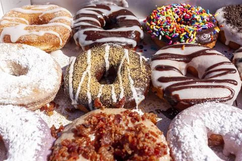 Flat lay image of fresh made store bought donuts in paper box fresh out of th Stock Photos