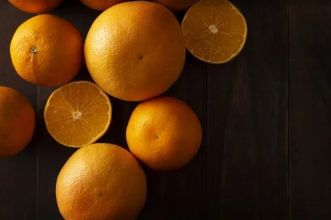 Flat lay image of a ripe orange cut in half and several whole oranges on brow Stock Photos