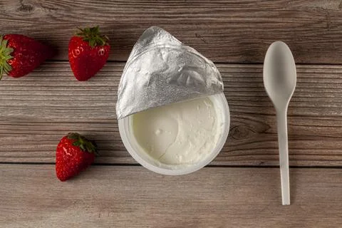 Flat lay image of a store bought plastic cup of plain low fat Greek Yogurt Stock Photos