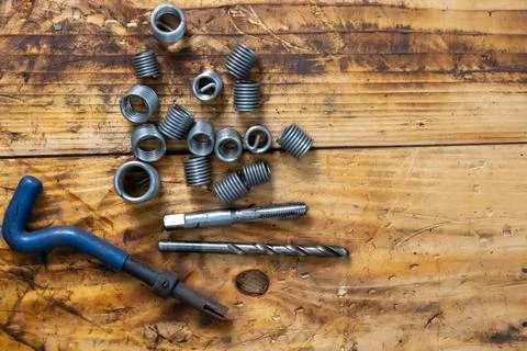 Flat lay of industrial thread repair kit with wire thread inserts and tools. Stock Photos