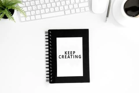 Flat lay with keep crearing motivational quote on diary, computer mouse and Stock Photos