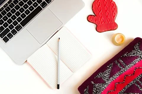 Flat lay of keyboard, notepad, pencil, Christmas cookie and knitted jumper Stock Photos
