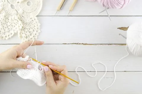 Flat lay knitting workspace white colors on wooden planks background. Needlework Stock Photos