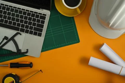 Flat lay laptop computer, blueprints, hardhat and coffee cup on yellow Stock Photos