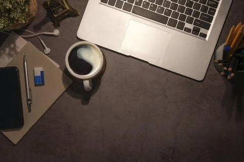 Flat lay laptop computer, smart phone, coffee cup and stationery on black tab Stock Photos