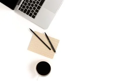 Flat lay of laptop, mug of coffee and stationery on a white background. Stock Photos